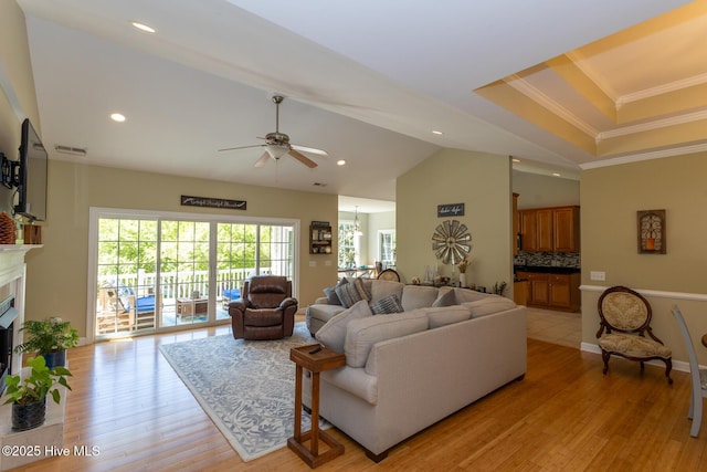 living area featuring a fireplace, light wood-style flooring, a ceiling fan, recessed lighting, and ornamental molding