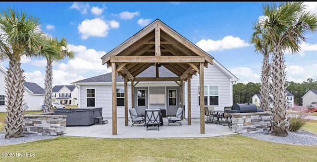 604 Winfall Dr, Holly Ridge, NC 28445 - back of property featuring a hot tub, a patio area, a lawn, and a gazebo
