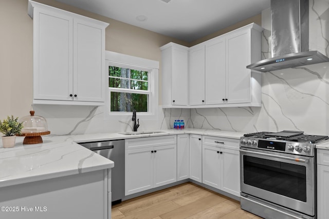44 S Shamrock Dr, Foxfire Village, NC 27281 - kitchen featuring wall chimney exhaust hood, appliances with stainless steel finishes, a sink, white cabinets, and light stone countertops