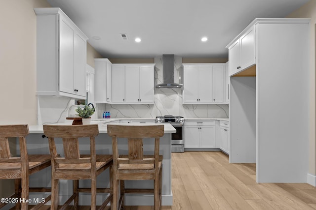 44 S Shamrock Dr, Foxfire Village, NC 27281 - kitchen featuring wall chimney exhaust hood, stainless steel gas range, light countertops, light wood-type flooring, and recessed lighting
