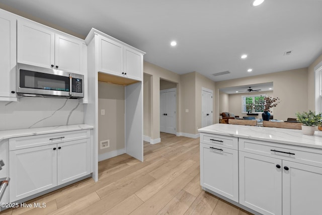 44 S Shamrock Dr, Foxfire Village, NC 27281 - kitchen with stainless steel microwave, white cabinetry, recessed lighting, ceiling fan, and light wood-style flooring