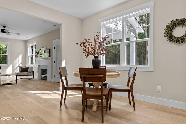 44 S Shamrock Dr, Foxfire Village, NC 27281 - dining area featuring light wood-style flooring, baseboards, a ceiling fan, and a glass covered fireplace