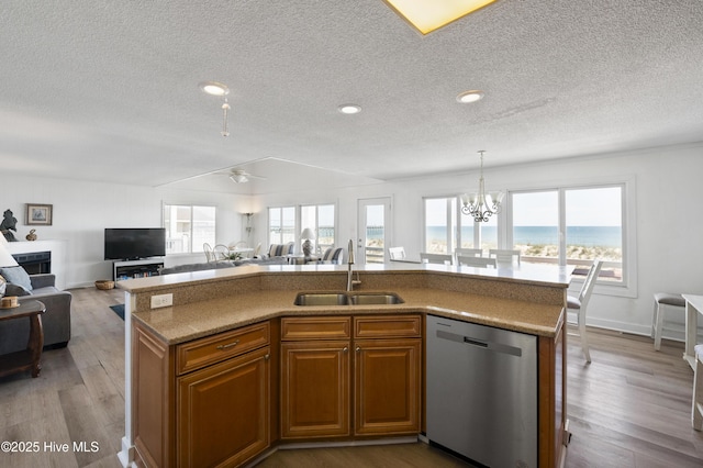 kitchen with a breakfast bar area, stainless steel appliances, brown cabinets, and a textured ceiling