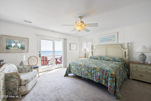 bedroom with crown molding, visible vents, attic access, and light colored carpet