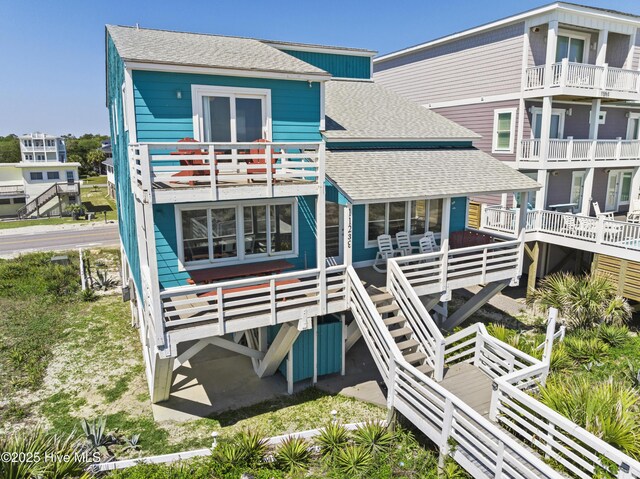 back of property featuring a shingled roof and a balcony