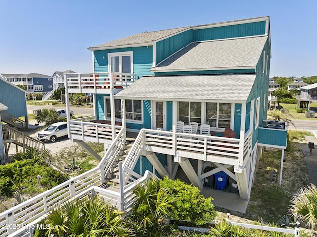 back of property featuring a shingled roof and a balcony