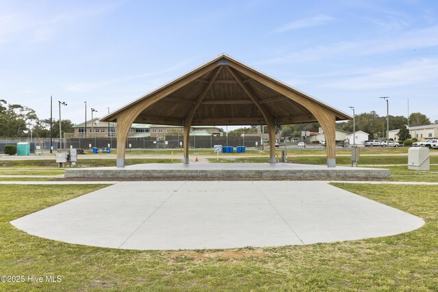 view of property's community with a gazebo, a lawn, and fence