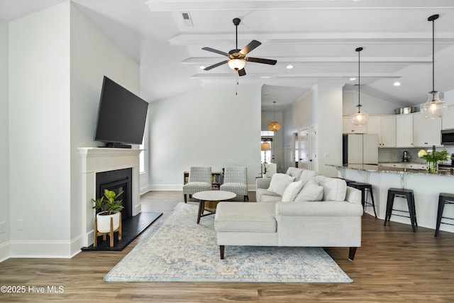 living area featuring ceiling fan, visible vents, baseboards, lofted ceiling with beams, and dark wood-type flooring