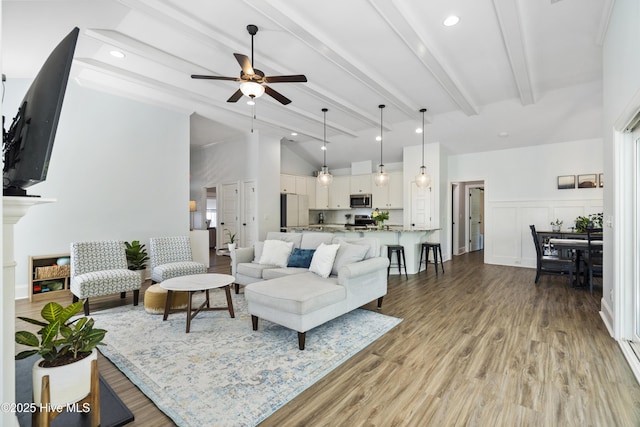 living area with a ceiling fan, lofted ceiling with beams, and light wood-type flooring