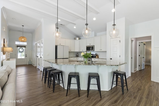 kitchen featuring freestanding refrigerator, dark wood-style flooring, stainless steel microwave, and white cabinets