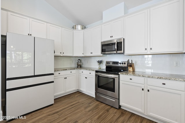 kitchen with white cabinets, appliances with stainless steel finishes, and vaulted ceiling