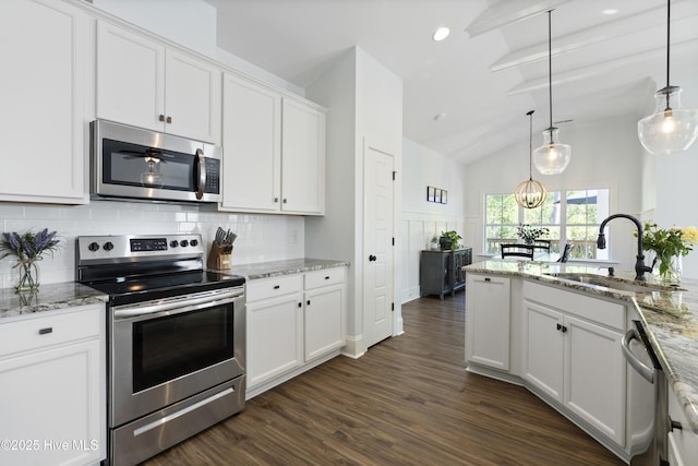 kitchen with appliances with stainless steel finishes, a sink, vaulted ceiling with beams, tasteful backsplash, and dark wood-style floors