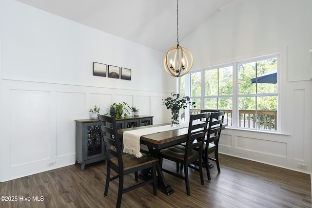 dining room with an inviting chandelier, dark wood finished floors, lofted ceiling, and a decorative wall
