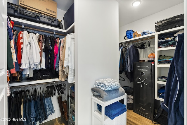 walk in closet with wood finished floors