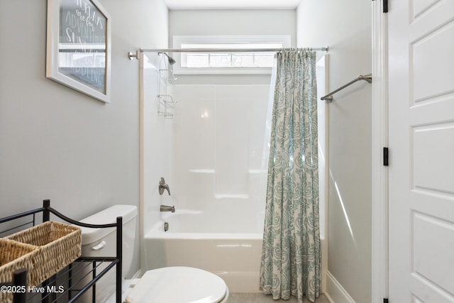 full bathroom featuring shower / bath combination with curtain and toilet