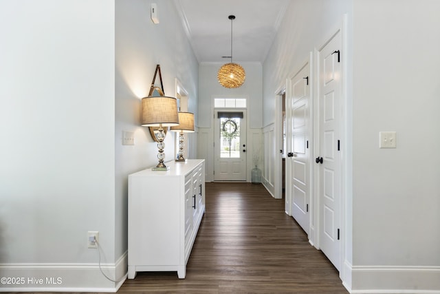 entryway featuring crown molding, baseboards, and dark wood finished floors
