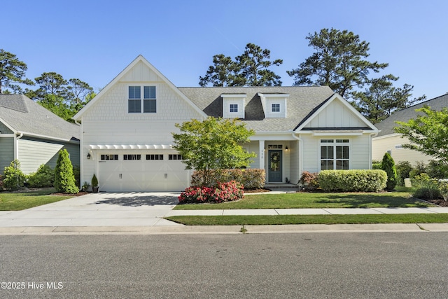 craftsman-style house with board and batten siding, a front yard, roof with shingles, concrete driveway, and an attached garage
