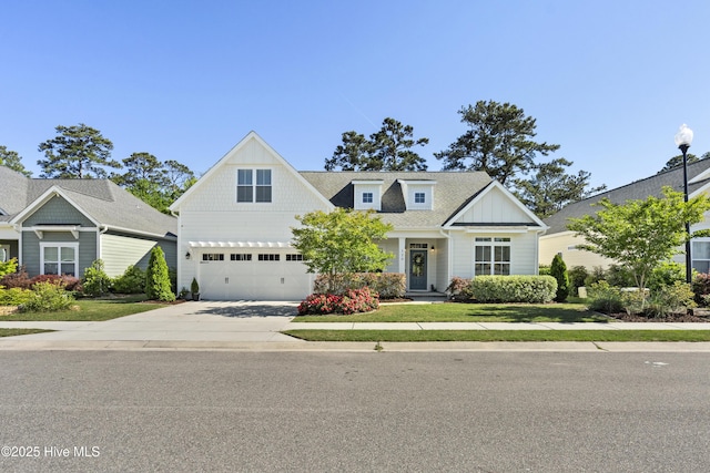 view of front facade featuring concrete driveway, roof with shingles, a front yard, and a garage