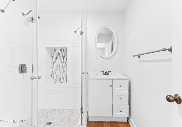 full bathroom featuring vanity, a stall shower, and wood finished floors