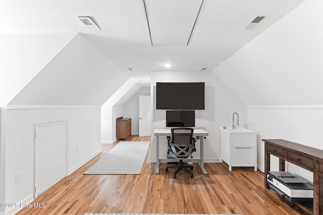 office featuring attic access, visible vents, wood finished floors, and vaulted ceiling