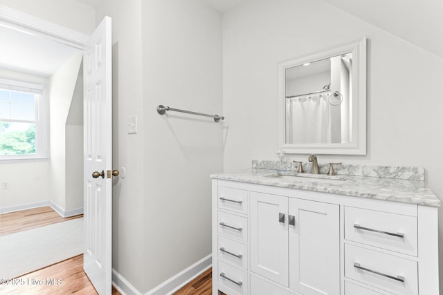 bathroom featuring baseboards, wood finished floors, and vanity