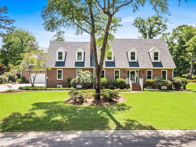 cape cod-style house featuring brick siding, driveway, and a front yard
