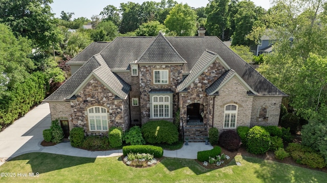 2220 Bel Arbor Pl, Wilmington, NC 28403 - view of front of house with stone siding, a front lawn, and a chimney