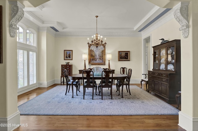2220 Bel Arbor Pl, Wilmington, NC 28403 - dining area with a chandelier, a raised ceiling, wood finished floors, and ornamental molding