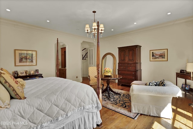 2220 Bel Arbor Pl, Wilmington, NC 28403 - bedroom featuring light wood-type flooring, crown molding, arched walkways, a chandelier, and recessed lighting