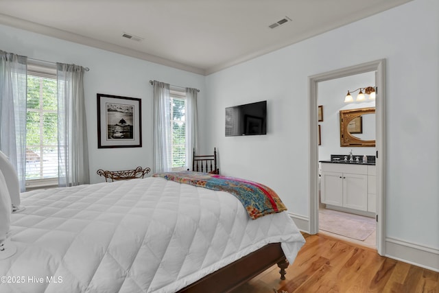 2220 Bel Arbor Pl, Wilmington, NC 28403 - bedroom with multiple windows, light wood-type flooring, and connected bathroom