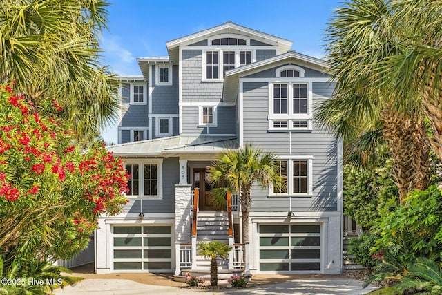 805 S Lumina Ave, Wrightsville Beach, NC 28480 - view of front facade featuring metal roof, an attached garage, a standing seam roof, and driveway