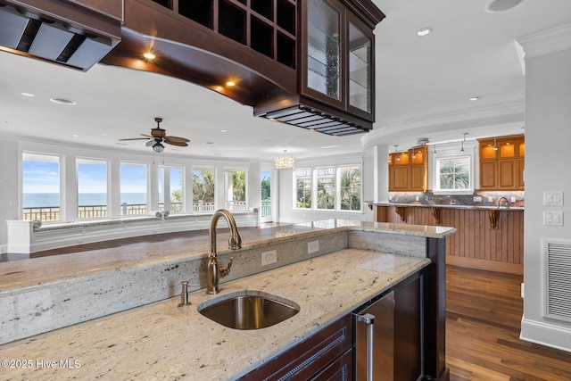 805 S Lumina Ave, Wrightsville Beach, NC 28480 - kitchen with a kitchen bar, a sink, crown molding, light stone countertops, and recessed lighting