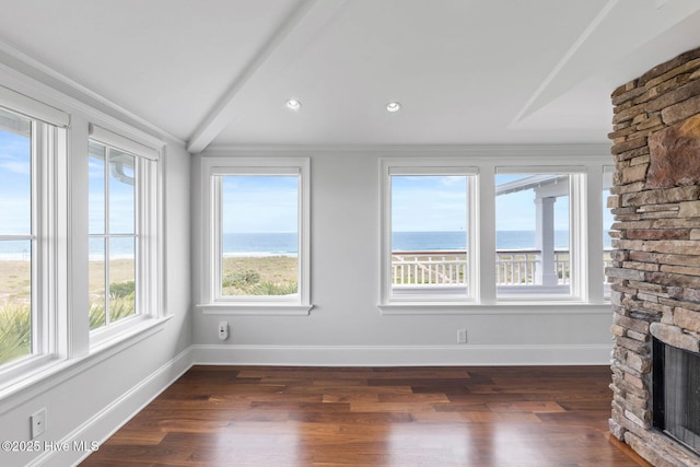 805 S Lumina Ave, Wrightsville Beach, NC 28480 - unfurnished living room featuring dark wood finished floors, a water view, a fireplace, and baseboards
