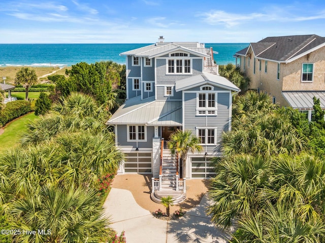 805 S Lumina Ave, Wrightsville Beach, NC 28480 - coastal inspired home featuring a water view, a garage, metal roof, driveway, and stairs