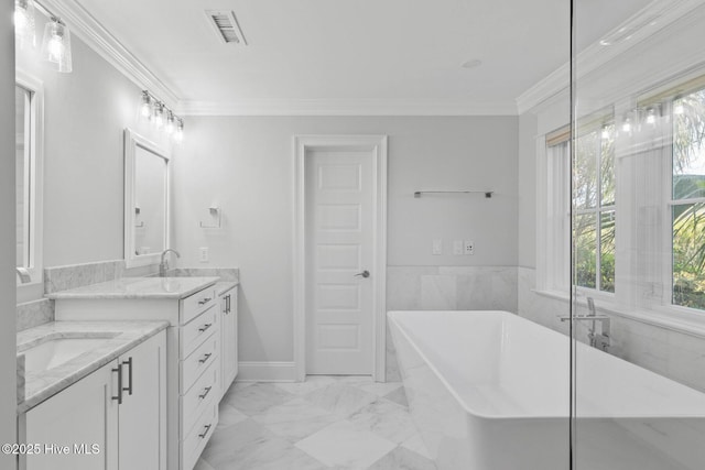 805 S Lumina Ave, Wrightsville Beach, NC 28480 - bathroom with two vanities, visible vents, a freestanding tub, marble finish floor, and ornamental molding