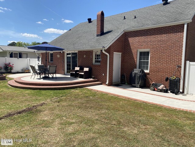 612 Blaney St, Clinton, NC 28328 - back of house featuring brick siding, a patio area, a lawn, and fence