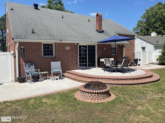 612 Blaney St, Clinton, NC 28328 - rear view of house with a fire pit, roof with shingles, brick siding, a patio area, and a yard