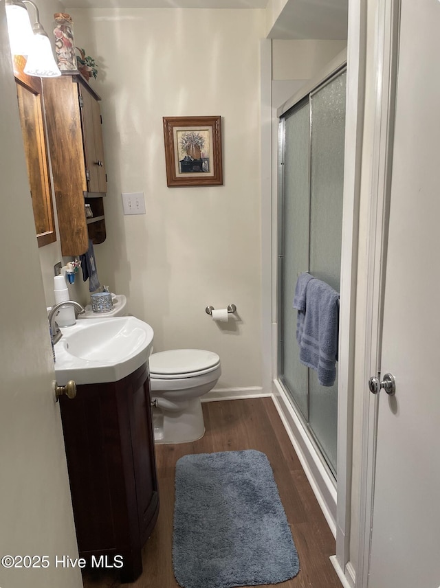 612 Blaney St, Clinton, NC 28328 - full bath featuring vanity, wood finished floors, toilet, baseboards, and a stall shower