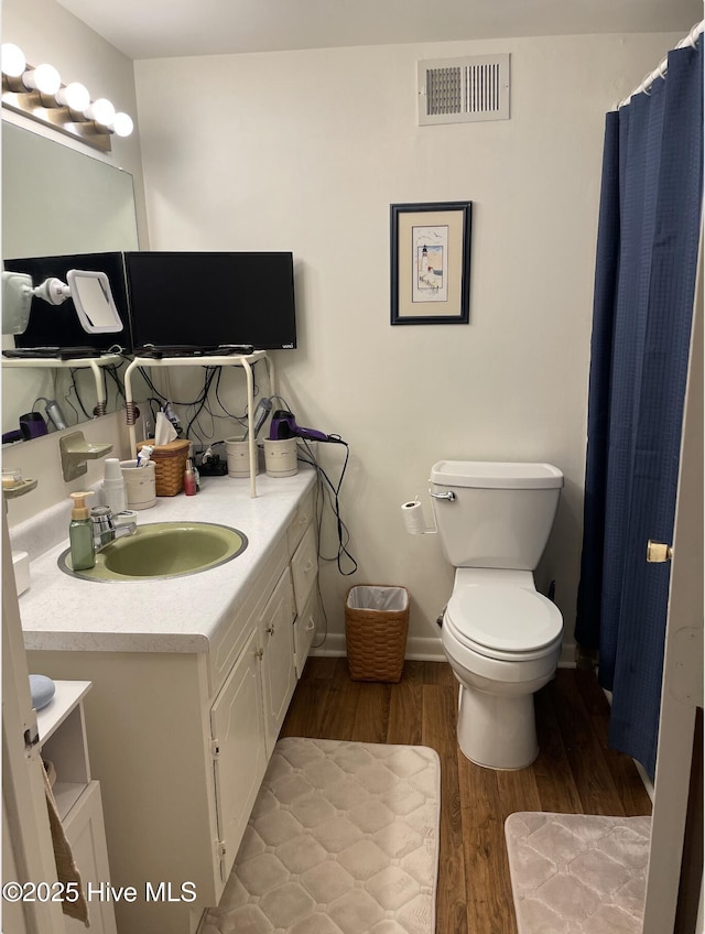 612 Blaney St, Clinton, NC 28328 - bathroom with visible vents, wood finished floors, vanity, baseboards, and toilet