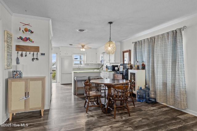 415 W Boardwalk Blvd, Atlantic Beach, NC 28512 - dining area with crown molding, a textured ceiling, dark wood-type flooring, and a ceiling fan