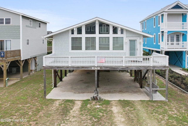 1024 Ocean Blvd W, Holden Beach, NC 28462 - view of front of property with a carport, driveway, a wooden deck, and a patio area
