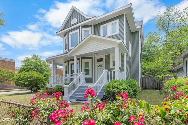 view of front of property with a porch and fence