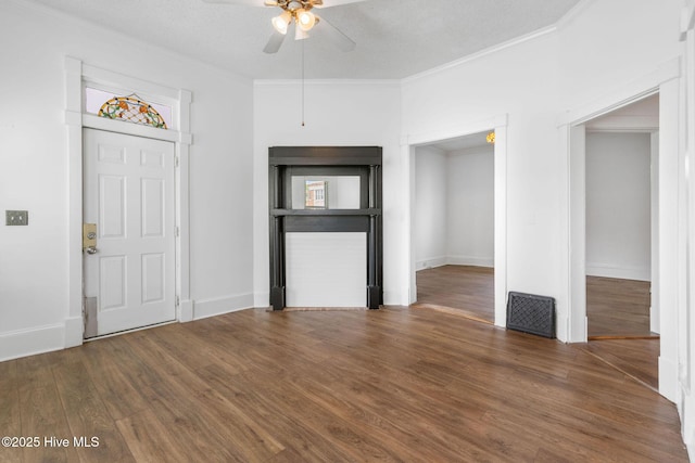 foyer entrance with baseboards, ceiling fan, ornamental molding, and wood finished floors