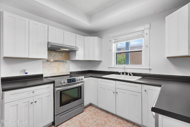 kitchen featuring ventilation hood, dark countertops, a sink, and electric stove