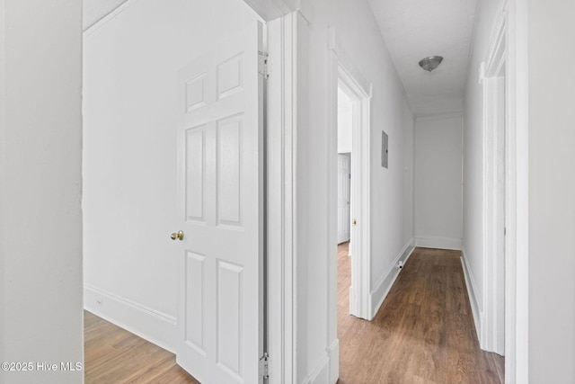 corridor with baseboards, visible vents, and wood finished floors