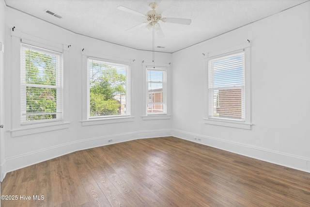 unfurnished dining area with baseboards, visible vents, plenty of natural light, and wood finished floors
