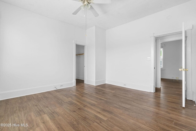empty room with baseboards, ceiling fan, and wood finished floors