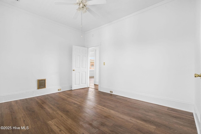 spare room featuring crown molding, ceiling fan, baseboards, wood finished floors, and visible vents