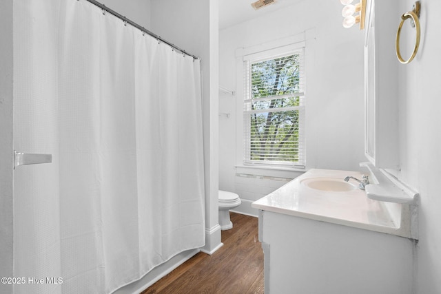 bathroom featuring vanity, wood finished floors, visible vents, and toilet