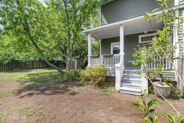 property entrance featuring fence and covered porch